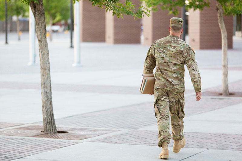 Active-duty service member walking through college