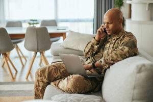 military man using laptop and phone