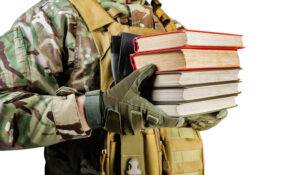 military soldier holding stack books