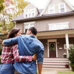 military couple in front of new home