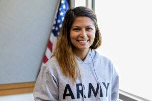 army veteran smiling in front of flag