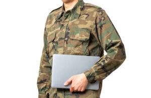 soldier with a laptop under his arm