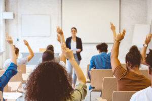 eager classroom of learners raised hands