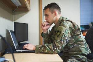 in-service male soldier at laptop in room