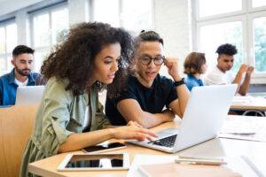 students learning together on laptop in class