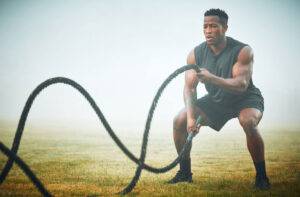 man exercising with battle ropes