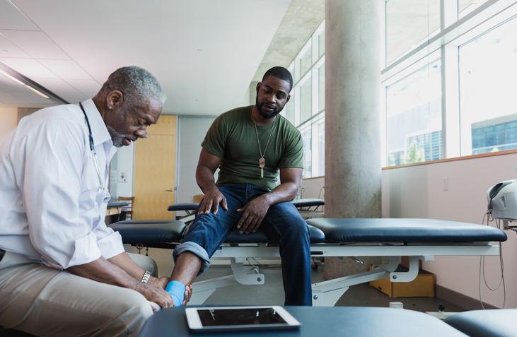 a doctor examines military members ankle