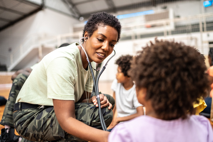 Army doctor examining refugee children