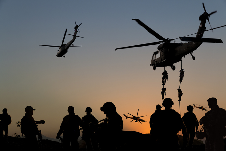 Silhouettes of soldiers on Military Mission at dusk