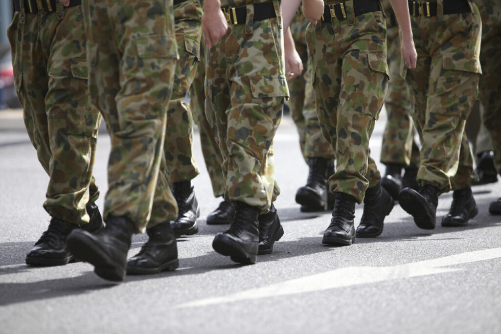Camouflage pants with boots; ROTC students marching.