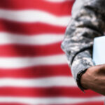 student soldier in uniform and carrying books